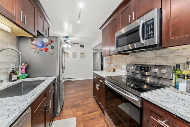 a kitchen with stainless steel appliances granite countertop a sink stove and cabinets