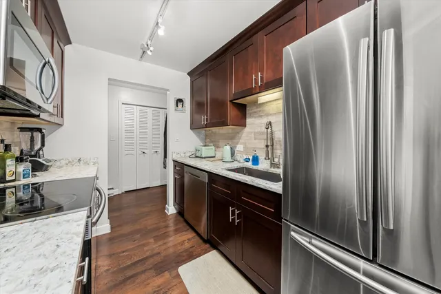 a kitchen with stainless steel appliances granite countertop a refrigerator and a sink