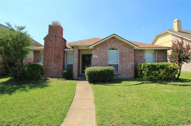 a front view of a house with yard and green space