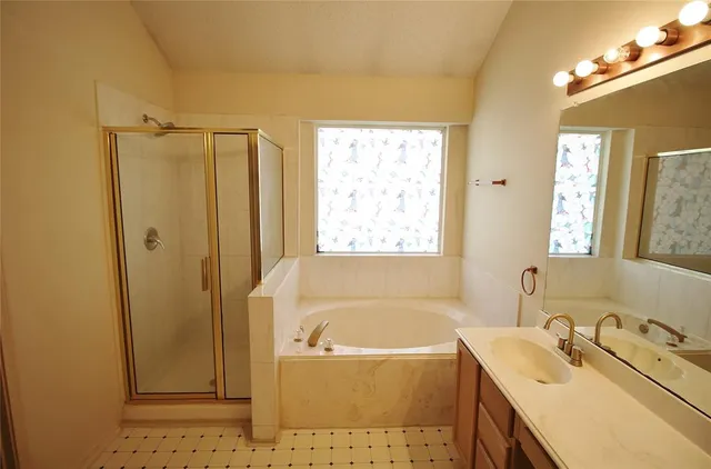 a bathroom with a tub sink and mirror