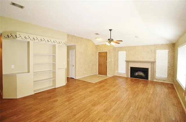 a view of an empty room with a fireplace and a window