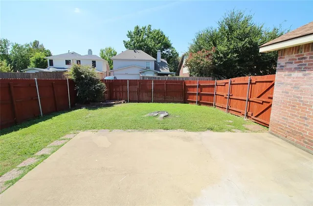 a view of a backyard with wooden fence