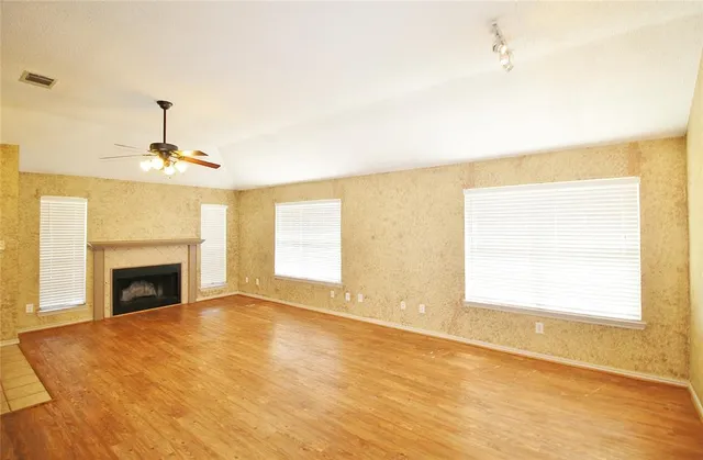 a view of empty room with fireplace and wooden floor