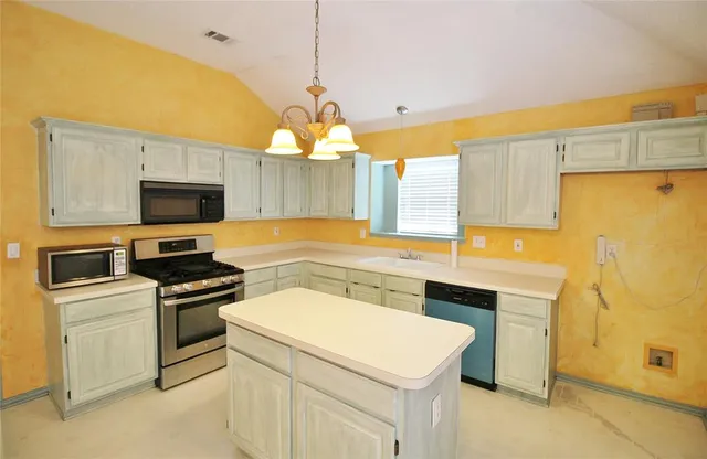 a kitchen that has a sink a stove and a microwave