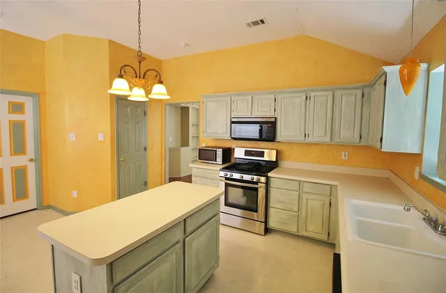 a kitchen with a refrigerator a stove a sink and a microwave