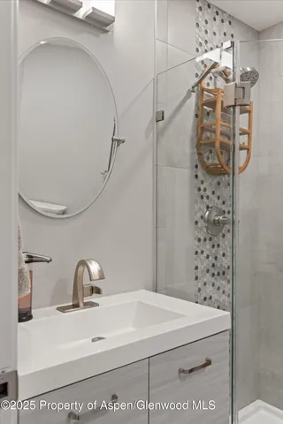 a bathroom with a sink a mirror and shower