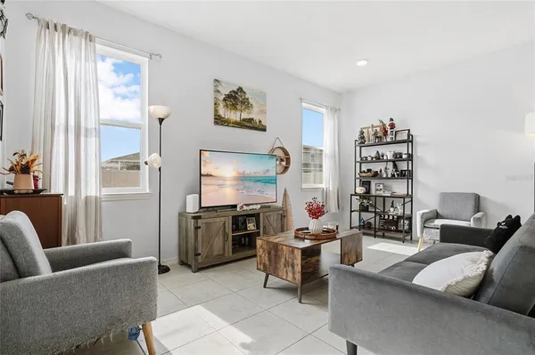 a living room with furniture a window and a flat screen tv