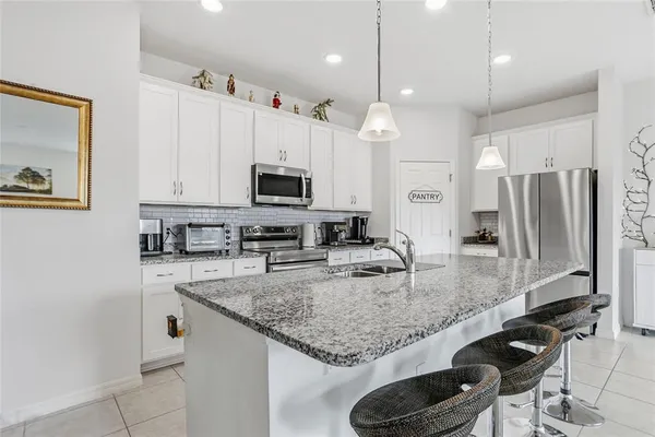 a kitchen with stainless steel appliances granite countertop a sink refrigerator and microwave