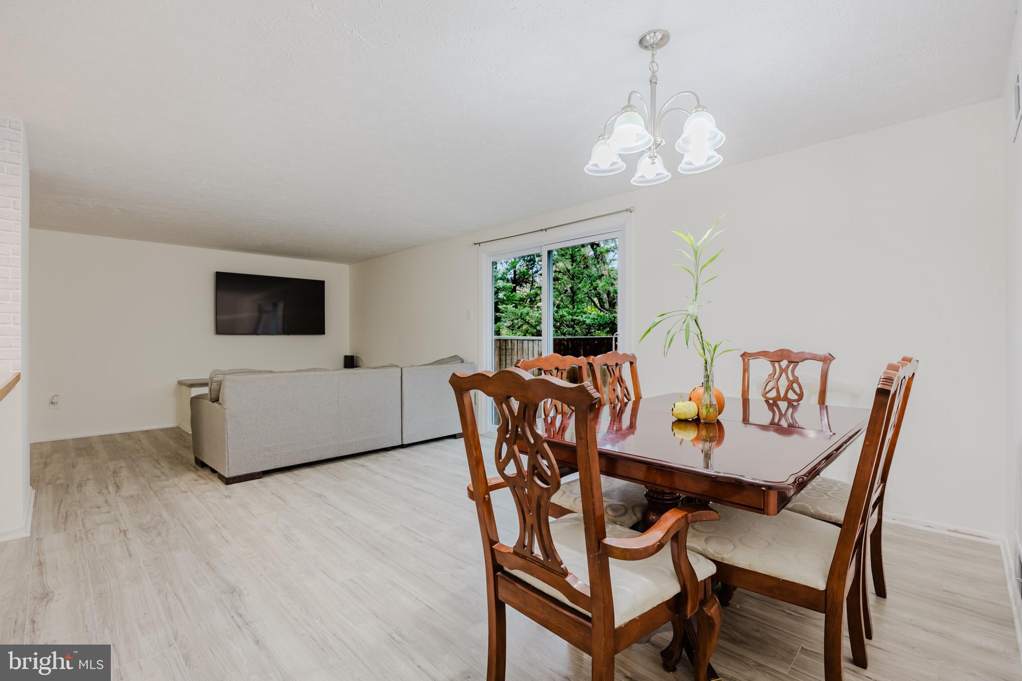 19621 Gunners Branch Road, Unit 823 Germantown, MD 20876 - Photo 22 of 49 a view of a dining room with furniture and wooden floor