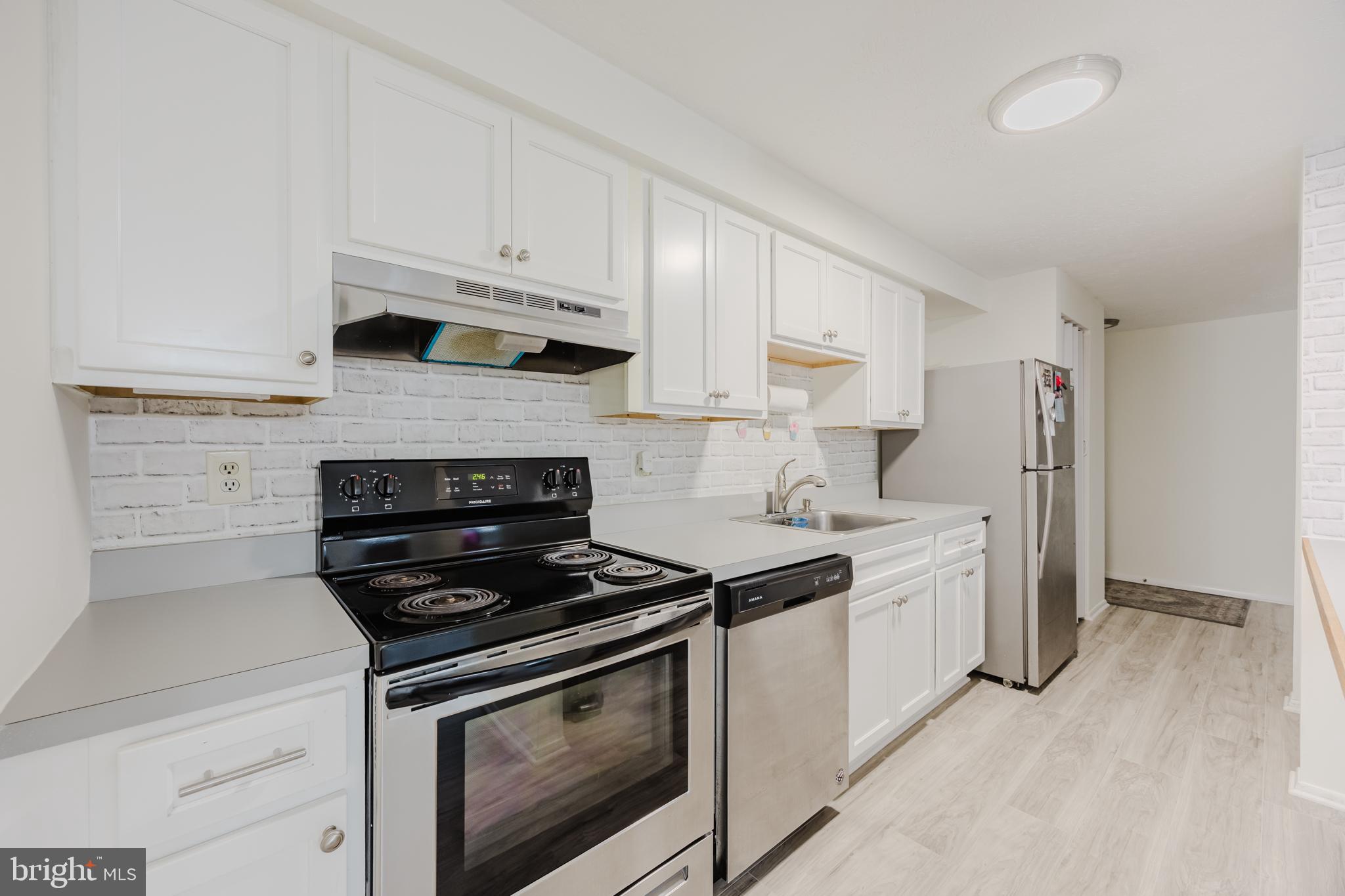 19621 Gunners Branch Road, Unit 823 Germantown, MD 20876 - Photo 23 of 49 a kitchen with stainless steel appliances white cabinets and stove