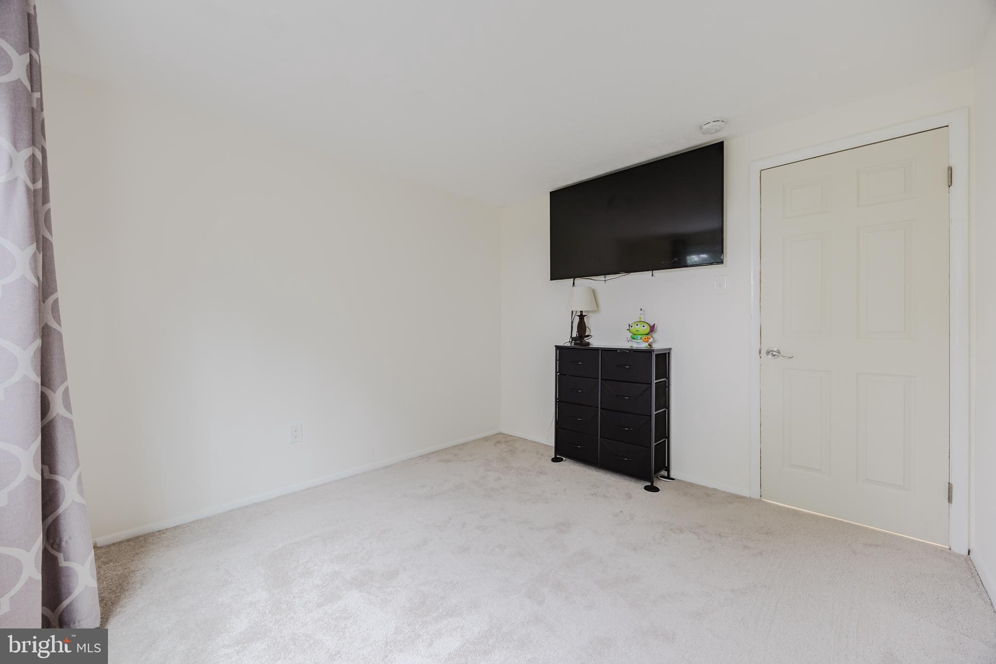19621 Gunners Branch Road, Unit 823 Germantown, MD 20876 - Photo 43 of 49 a living room with a flat screen tv and a lamp
