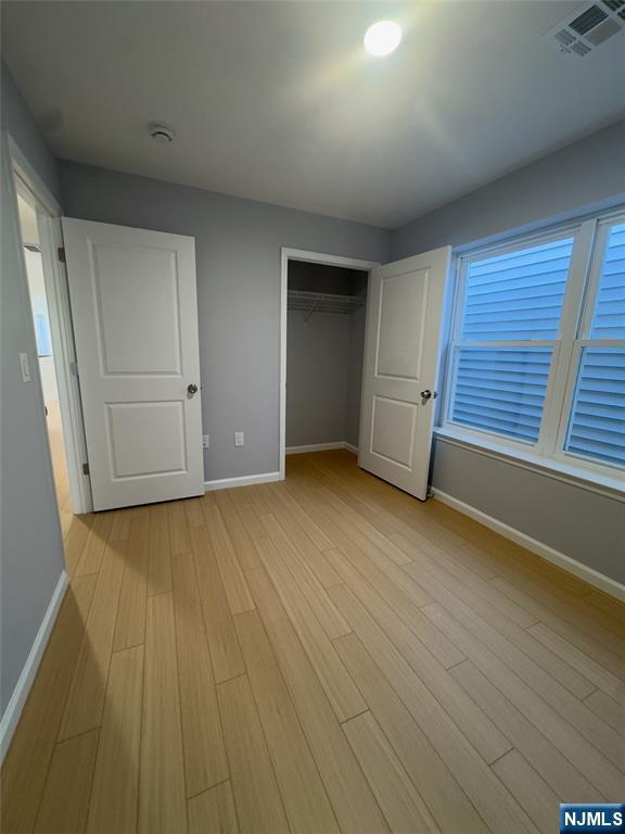 29 Isabella Avenue, Unit 2 Newark, NJ 07106 - Photo 20 of 35 an empty room with wooden floor and windows
