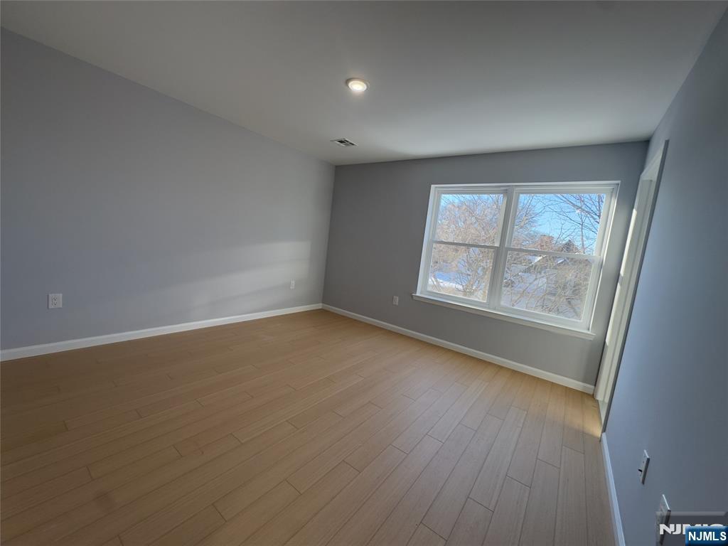 29 Isabella Avenue, Unit 2 Newark, NJ 07106 - Photo 26 of 35 an empty room with wooden floor and windows
