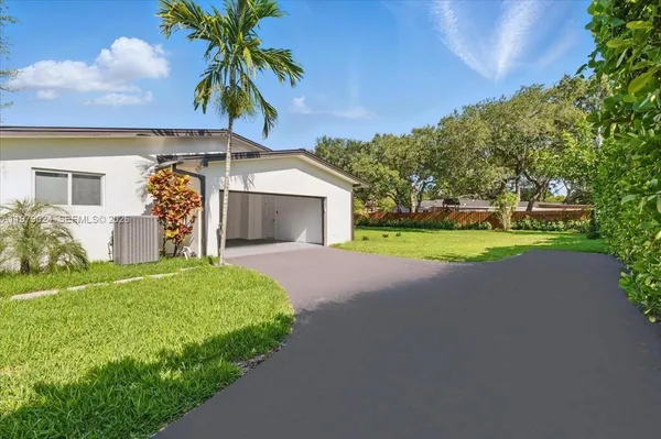 a front view of a house with a garden and yard