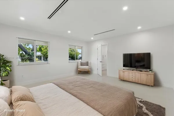 a bedroom with furniture and a flat screen tv