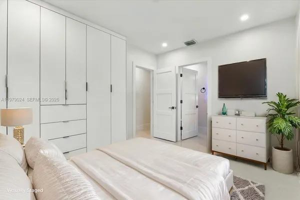 a bedroom with a bed and a flat screen tv