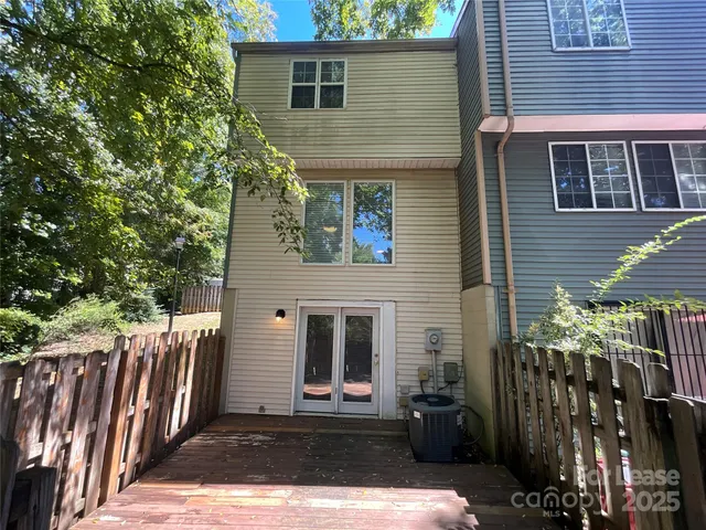 a view of a house with a small yard and wooden floor and fence