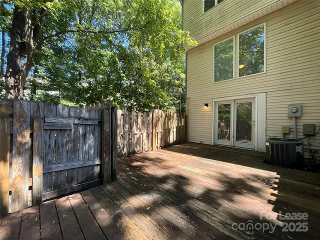 a view of backyard with wooden fence and a large tree