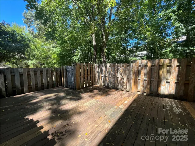 a view of wooden fence under a large tree