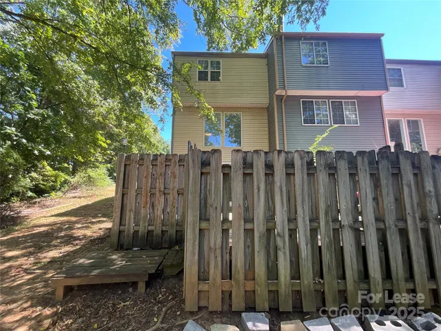 a view of a house with a wooden fence