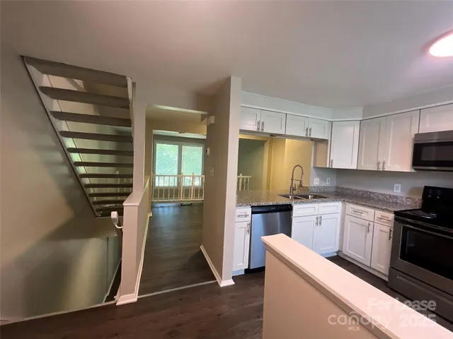 a kitchen with stainless steel appliances granite countertop a stove a sink and a refrigerator