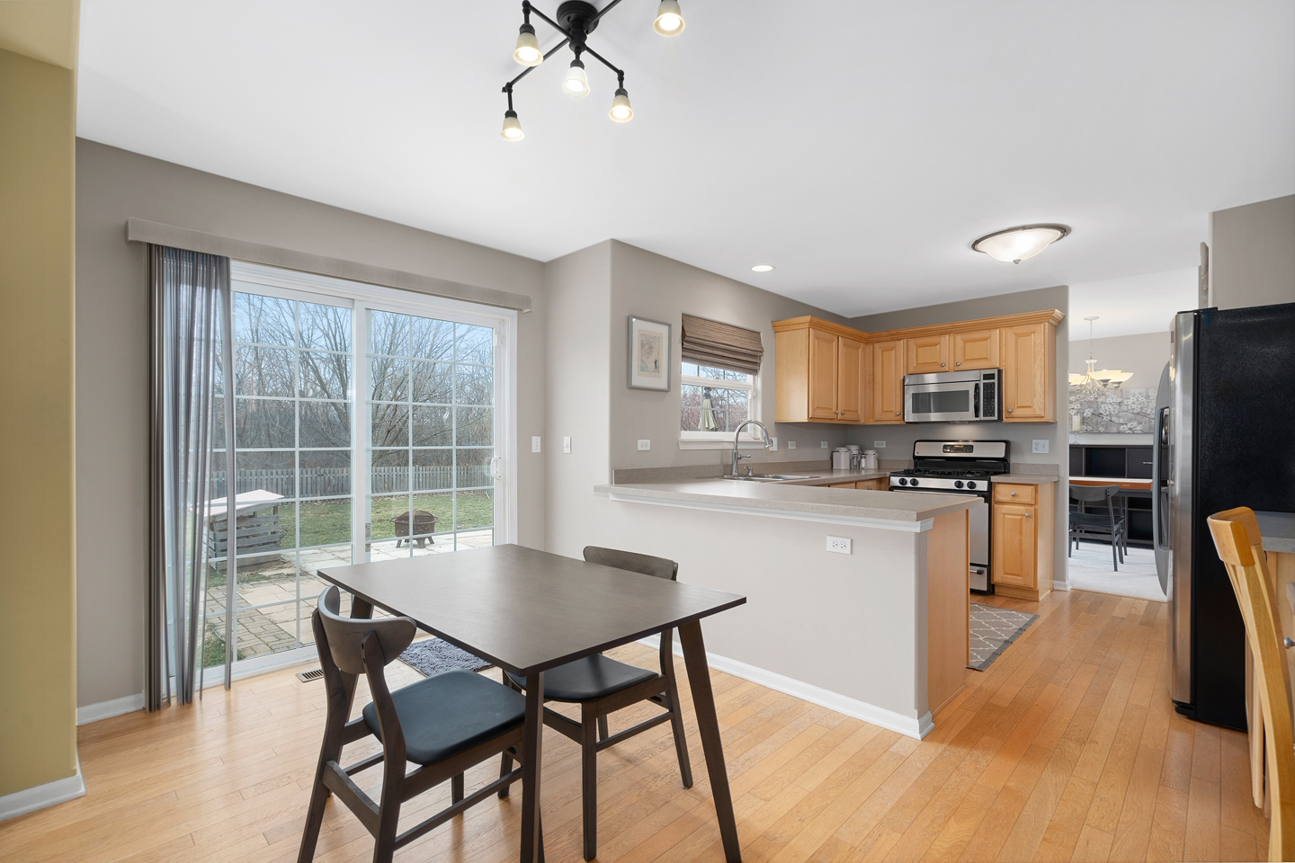 751 Sumac Drive Aurora, IL 60506 - Photo 13 of 33 a kitchen with a table chairs refrigerator and microwave