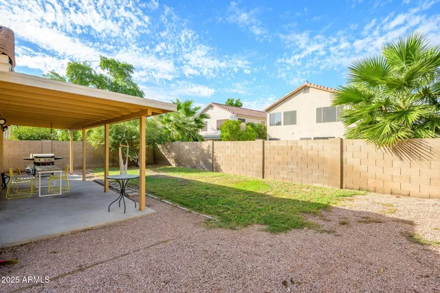 a view of a patio with a table and chairs under an umbrella
