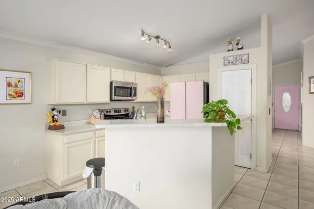 a kitchen with stainless steel appliances a refrigerator a sink a stove top oven a counter space and cabinets