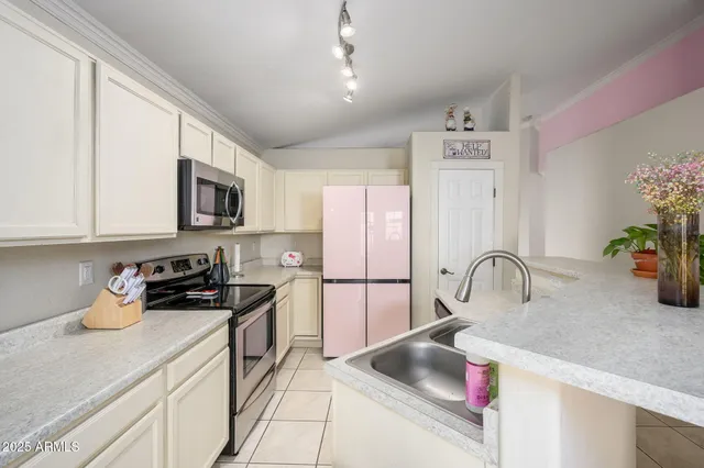 a kitchen with stainless steel appliances granite countertop a sink a stove and a refrigerator