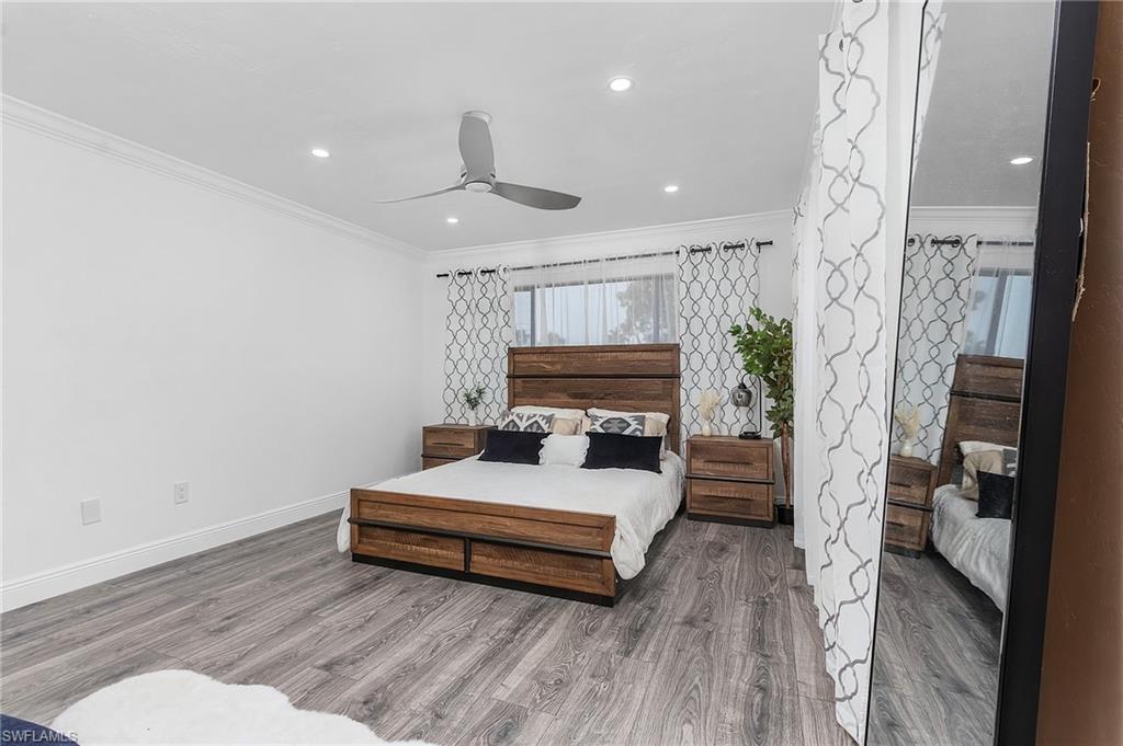 5841 Rattlesnake Hammock Road, Unit I208 Naples, FL 34113 - Photo 8 of 16 a spacious bedroom with a bed and a mirror