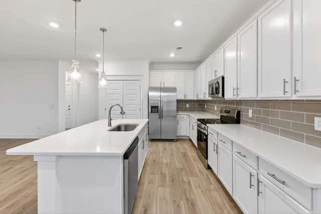 a kitchen with white cabinets and stainless steel appliances
