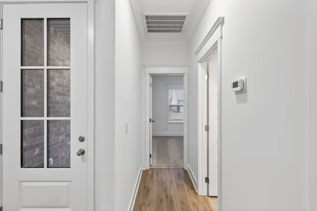 a view of a hallway with wooden floor and entryway