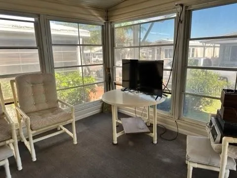 a view of a workspace with furniture and a window