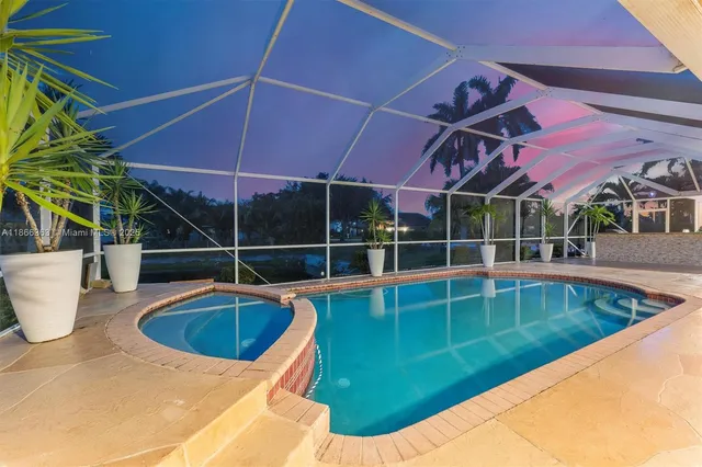 a view of a swimming pool with a table and chairs under an umbrella