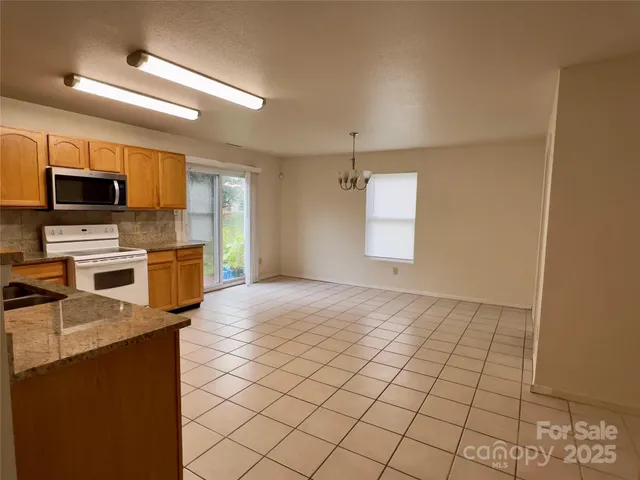 a kitchen with stainless steel appliances granite countertop a sink and a stove top oven with wooden floor