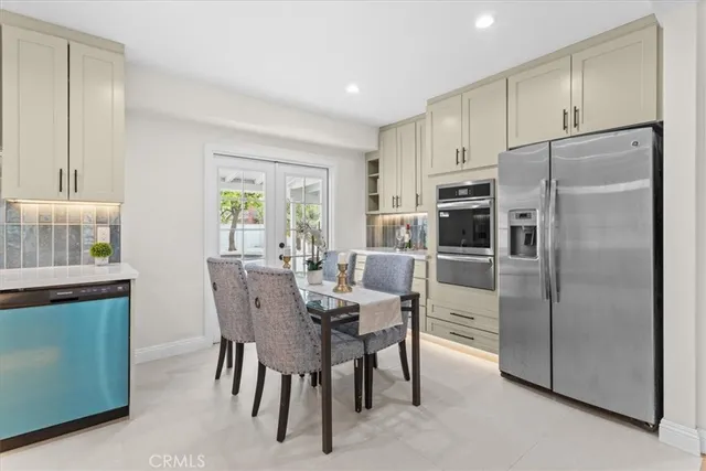 a kitchen with stainless steel appliances a refrigerator a stove a dining table and chairs