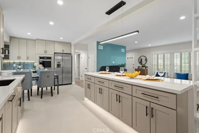 a large kitchen with kitchen island a sink stainless steel appliances and cabinets