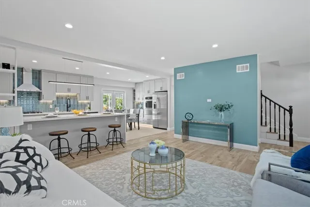 a living room with lots of furniture and a view of kitchen