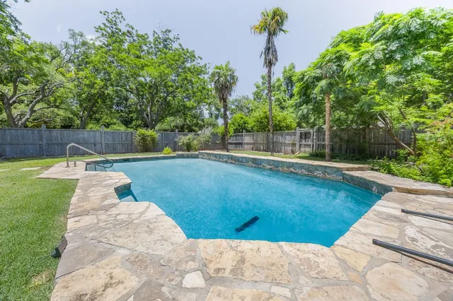 a view of a backyard with swimming pool
