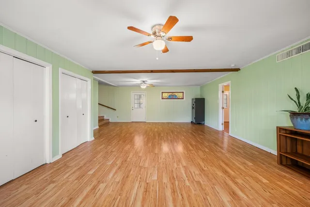 a view of empty room with wooden floor