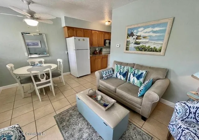 a living room with furniture a refrigerator and a couch