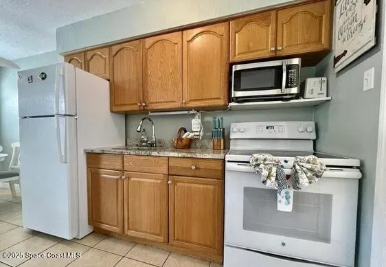 a kitchen with stainless steel appliances granite countertop a refrigerator and microwave
