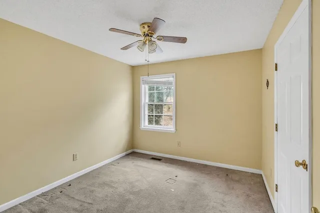 an empty room and a chandelier fan