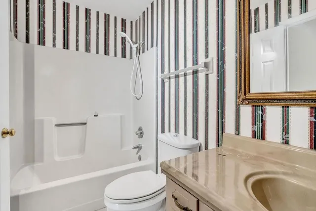 a bathroom with a granite countertop sink toilet and shower