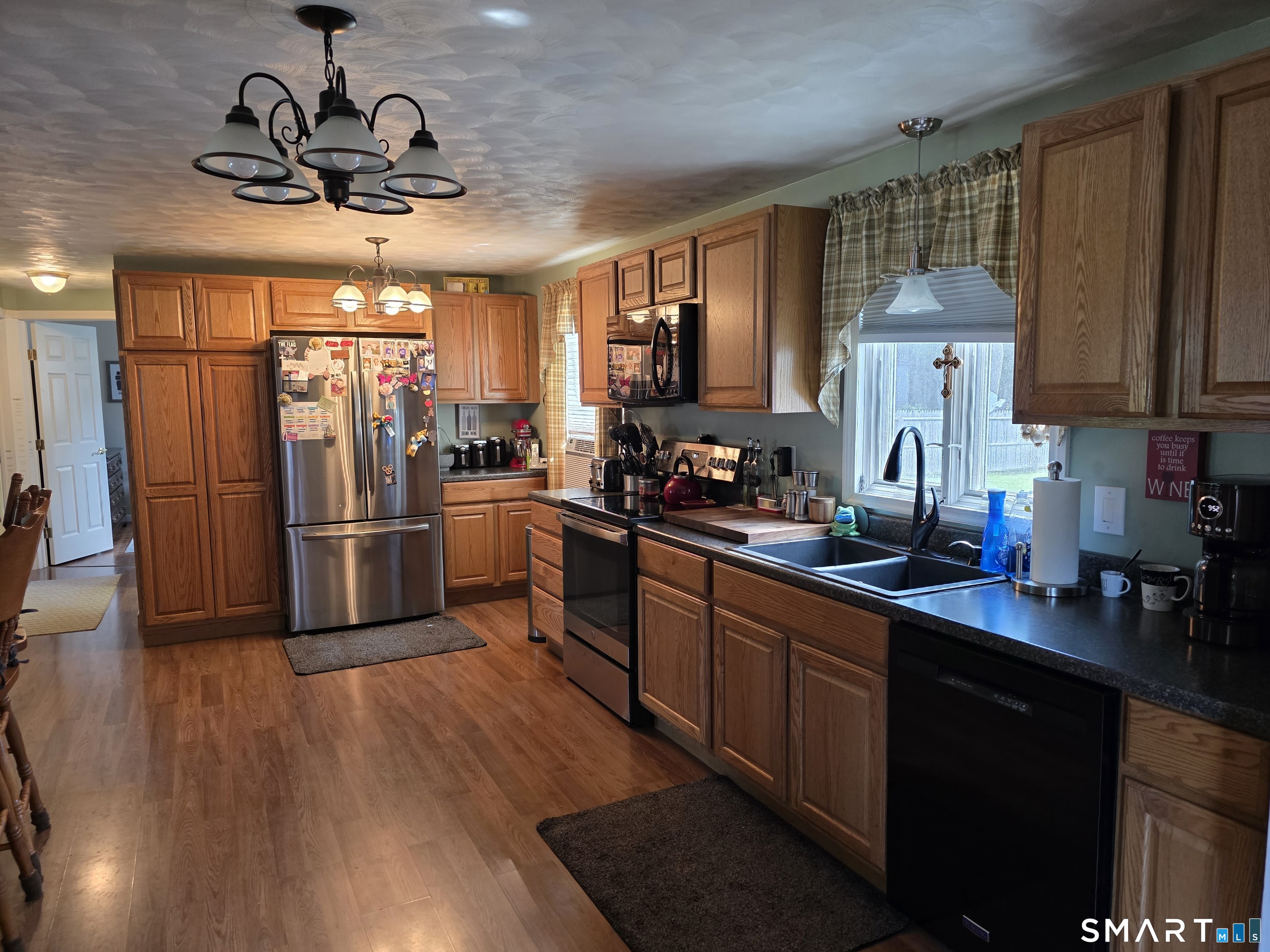 15 Van Buren Road Enfield, CT 06082 - Photo 15 of 40 a kitchen with stainless steel appliances granite countertop a refrigerator a sink dishwasher a stove and white countertops with wooden floor