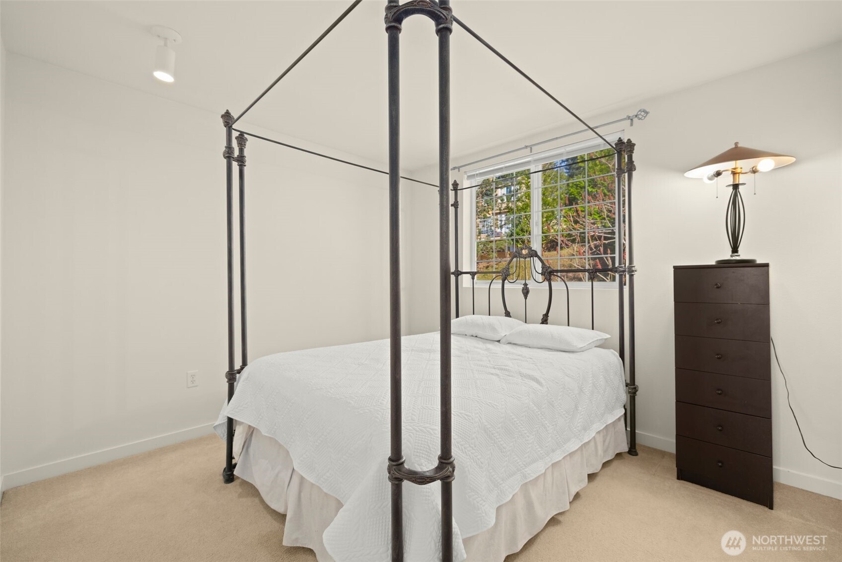 23120 Southeast Black Nugget Road, Unit E1 Issaquah, WA 98029 - Photo 23 of 39 a bedroom with a bed and a chandelier