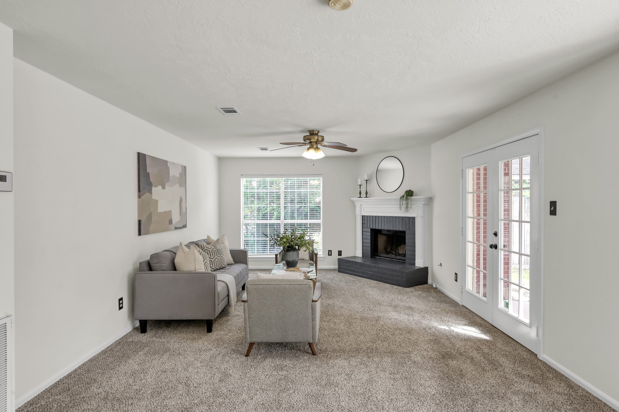 114 Regency Way Conroe, TX 77304 - Photo 10 of 48 Spacious, light and bright living room with cozy wood/gas fire place, double doors leading to covered back patio and ceiling fan.