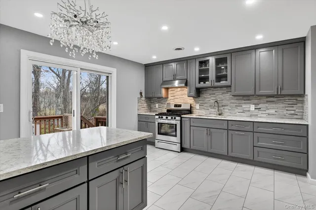 a kitchen with kitchen island granite countertop a sink window and cabinets