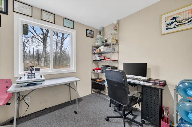 a view of a workspace with furniture and a window
