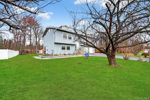 a front view of a house with garden and trees